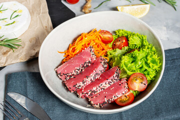 Salad with pieces of tuna and sesame with fresh vegetable salad on a plate. Authentic Japanese food