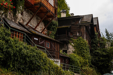 Hallstatt, Austria, 27 August 2021: Colorful scenic picturesque town street at summer day, mountain village near lake, Alps, UNESCO heritage, traditional wooden houses with balconies, flowers in pots