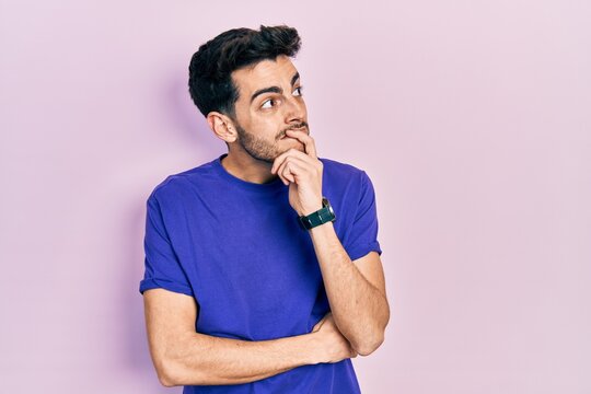 Young hispanic man wearing casual t shirt thinking worried about a question, concerned and nervous with hand on chin
