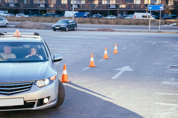 Learning to drive, people concept. Alert young woman student driver taking driving education lesson test from male instructor.