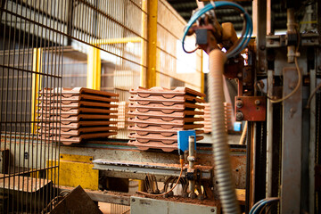 Factory production of roof tiles and construction materials. Automated industrial machine transporting packs of quality roof tiles for building industry.