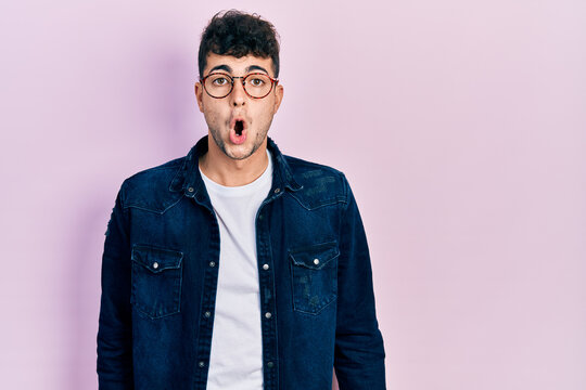 Young hispanic man wearing casual clothes and glasses afraid and shocked with surprise expression, fear and excited face.
