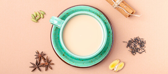 Healthy Indian beverage masala chai - tea hot drink with milk and spices in rustic green teacup...