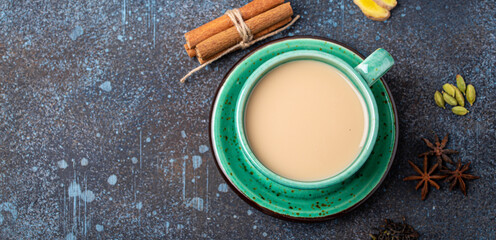 Healthy Indian beverage masala chai - tea hot drink with milk and spices in rustic green teacup...