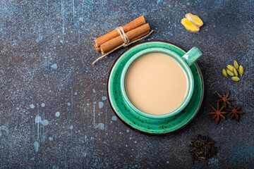 Healthy Indian beverage masala chai - tea hot drink with milk and spices in rustic green teacup...