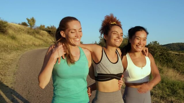 Group of sporty female friends running outdoors.