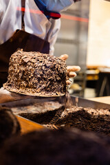 A hands of confectioner-chocolatier during at work. The making of cake 