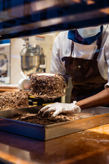 A hands of confectioner-chocolatier during at work. The making of cake 