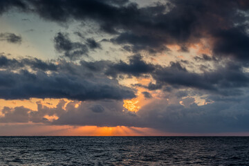 Naklejka na ściany i meble Seascape with a beautiful sunset over the surface of the sea