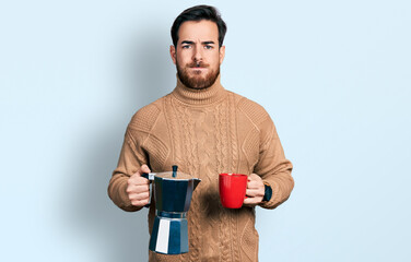 Young hispanic man drinking italian coffee skeptic and nervous, frowning upset because of problem. negative person.