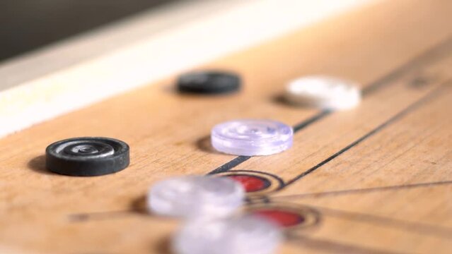 Closeup shot of Carrom coins on a carrom board. Indoor board game background. Carrom pieces on board in India