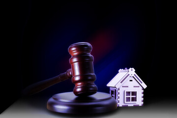 Abstract photo with wooden gavel and abstract house on black background as symbol of sale of mortgage or emergency housing at auction or as symbol of legal dispute over division of real estate