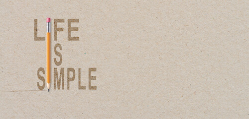 Life is simple - motivational quote on brown paper with orange pencil