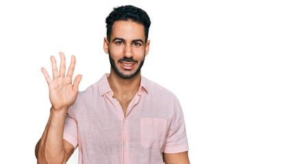 Naklejka premium Hispanic man with beard wearing casual shirt showing and pointing up with fingers number five while smiling confident and happy.