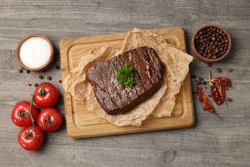 Concept of tasty food with beef steak on gray wooden background