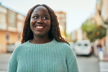 Young african woman smiling happy at the city