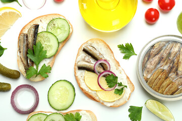 Concept of tasty snack with sandwiches with sprats on white background