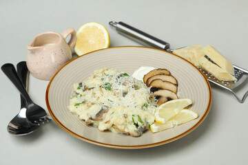 Concept of tasty food with risotto with mushrooms on light gray background