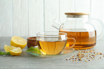 Concept of hot drink with buckwheat tea on gray textured table