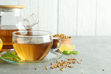 Concept of hot drink with buckwheat tea on gray textured table