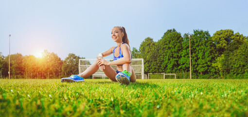 happy female runner sitting in small stadium after training - active lifestyle concept © Igor Link