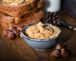 Hazelnut buttercream in bowl. Shelled hazelnuts, bread and milk with fresh nut butter cream.