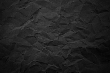 Textured crumpled black paper background.