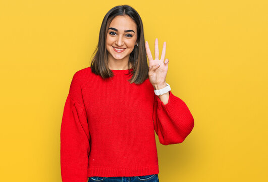 Beautiful brunette woman wearing casual winter sweater showing and pointing up with fingers number three while smiling confident and happy.