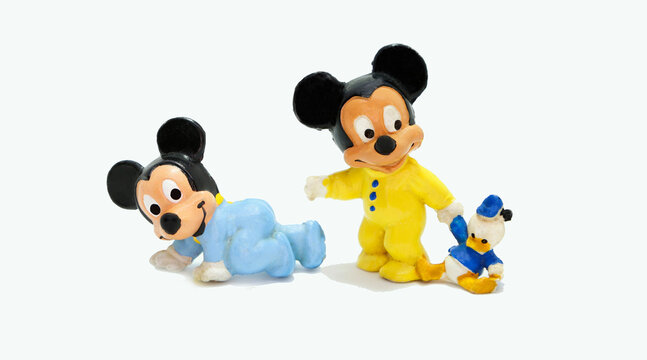 Mickey Mouse Babies. Baby Mickey Mouse. retro toy figure. Plastic doll. Vintage. Isolated. Cartoon character from Walt Disney Pictures Studios. . Nephew. Baby with Donald Duck plush.