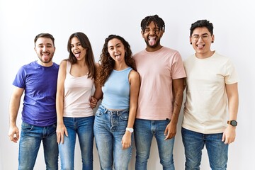 Group of young people standing together over isolated background sticking tongue out happy with funny expression. emotion concept.