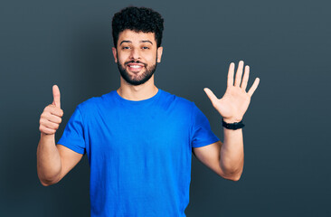Naklejka premium Young arab man with beard wearing casual blue t shirt showing and pointing up with fingers number six while smiling confident and happy.