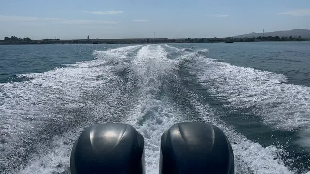 Motorboat with two outboard motors moves in area of Ballestas Islands and makes large wake, Peru