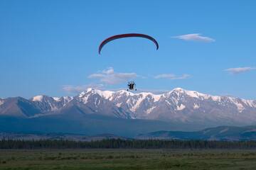 paraglider pilot is flying towards Mount Aktru