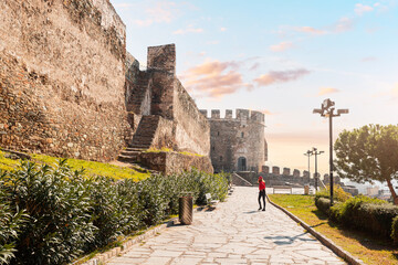 Tourist girl visitor walks to the entrance of the Trigonion or Chain Tower in Upper Town of Ano...