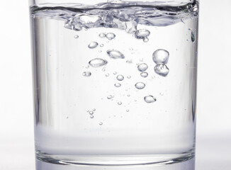Closeup of transperent glass of water and bubbles in it as a backgruond