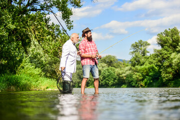 Success in business. retired dad and mature bearded son. Fly fishing adventures. happy fishermen. Good profit. friends men with fishing rod and net. hobby of businessman. retirement fishery