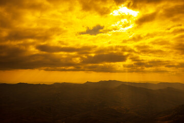 Landscape photo of sunset over clouds with mountain hill forest. in golden light tone.