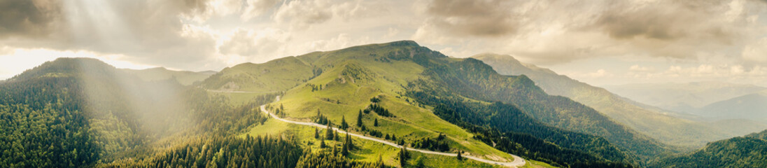 Obraz premium Aerial view of Transbucegi road in Bucegi Mountains from Romania in cloudy summer landscape. Amazing motorways of Romania.