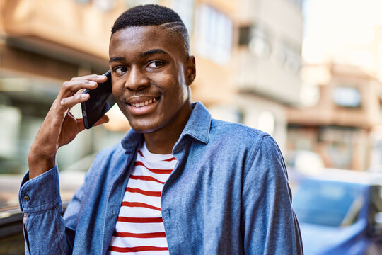 Young african american man smiling happy talking on the smartphone at the city.