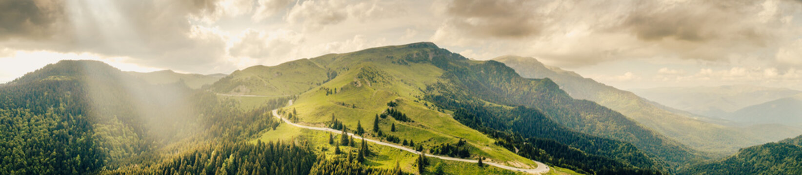 Aerial view of Transbucegi road in Bucegi Mountains from Romania in cloudy summer landscape. Amazing motorways of Romania.