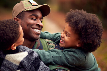 American Soldier In Uniform Returning Home On Leave To Family Greeted By Two Children