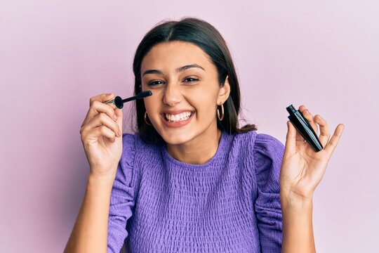 Young hispanic woman holding eyelashes curler smiling and laughing hard out loud because funny crazy joke.
