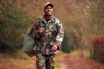 American Soldier In Uniform Carrying Kitbag Returning Home On Leave - Powered by Adobe