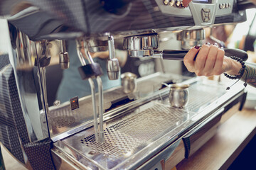 Female barista hand making coffee in cafeteria