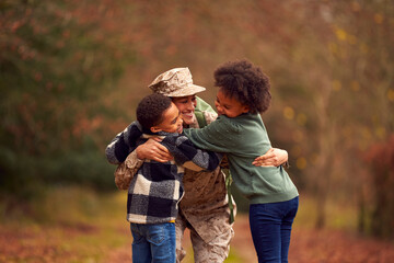 American Female Soldier In Uniform Returning Home On Leave To Family Greeted By Two Children