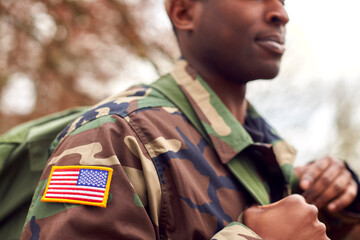 Close Up Of American Flag On Uniform Of Soldier Carrying Kitbag Returning Home On Leave
