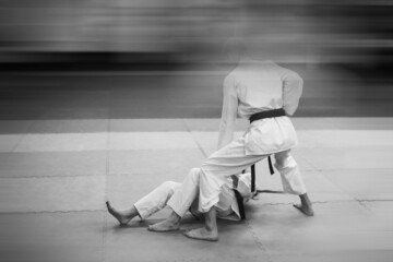Training fight in karate. Added blur effect for more motion effect. Retro style with imitation film grain. Black and white.