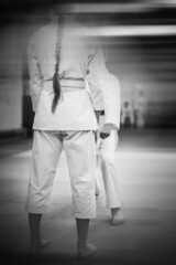 Fototapeta na wymiar Karate-do training and a healthy lifestyle. Added blur effect for more motion effect. Retro style with imitation film grain. Black and white.