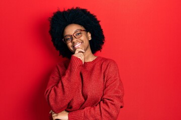Young african american woman wearing casual clothes and glasses smiling looking confident at the...