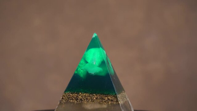 Spinning Orgone Generator Pyramid Isolated On Blurry Background. Close Up
